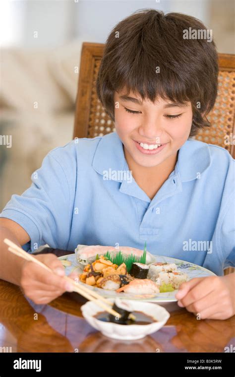 Young boy in dining room eating chinese food smiling Stock Photo - Alamy