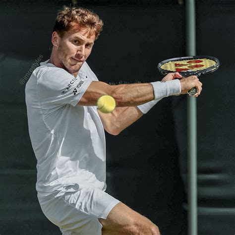 a man hitting a tennis ball with a racquet