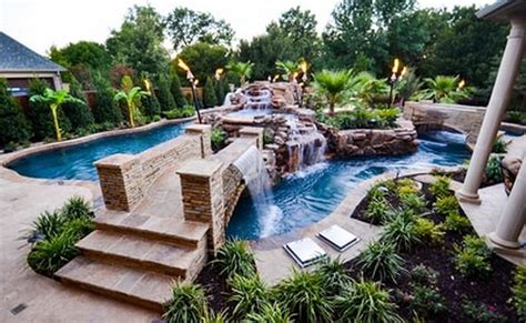 an outdoor swimming pool surrounded by landscaping and greenery, with steps leading up to it