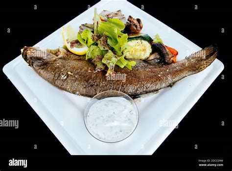 Whole fried trout with herbs and sauce Stock Photo - Alamy