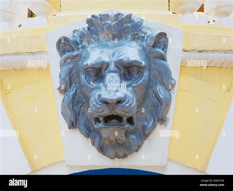 Silvery decorative lion head on a white yellow wall outdoors. Bas-relief Stock Photo - Alamy