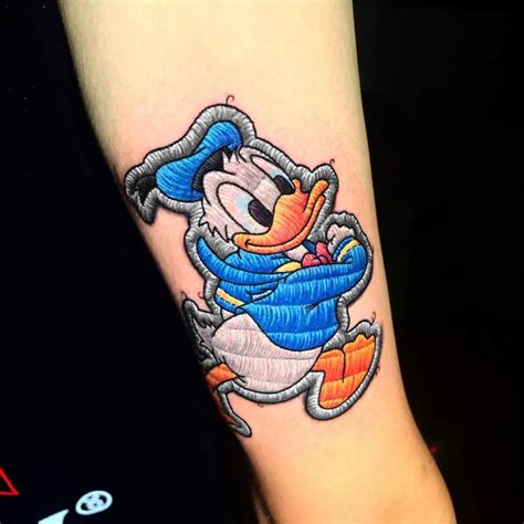 Donald Duck patch tattoo located on the shin.