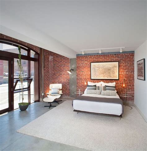 Gorgeous bedroom with brick wall, concrete flooring and midcentury décor [Design: Rockefeller ...