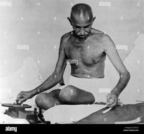 Mohandas karamchand gandhi spins cloth using traditional methods hi-res ...