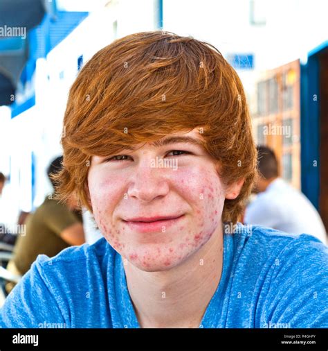 smart boy in puberty sitting on an outdoor table in the village Stock Photo - Alamy