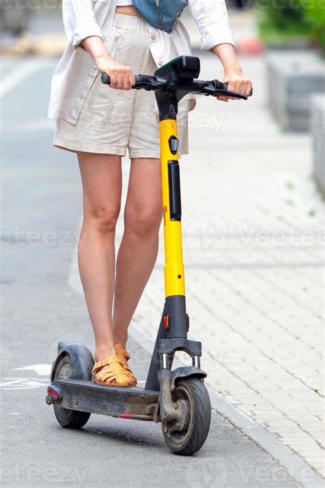 Long legged woman riding an electric scooter 16553069 Stock Photo at Vecteezy