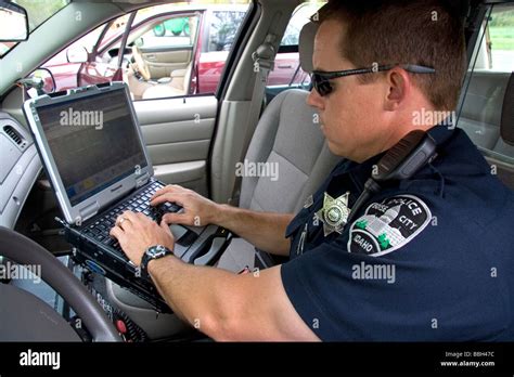 Police officer using a mobile data terminal computer inside a police ...