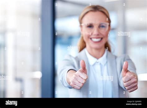 Now thats what Im talking about. Portrait of a mature businesswoman showing thumbs up in a ...