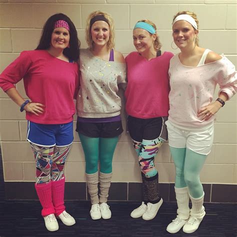 three women in pink shirts and colorful leggings posing for a photo together with one another
