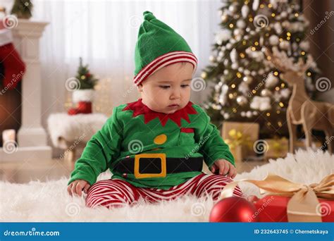 Baby Wearing Cute Elf Costume on Floor in Room Decorated for Christmas ...