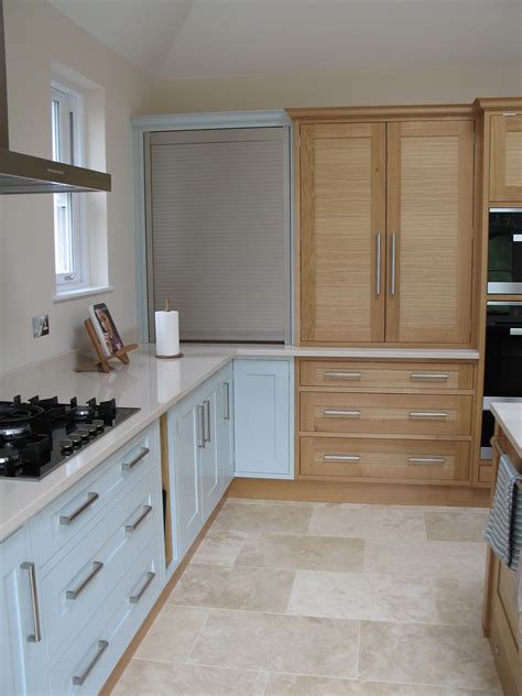 A stainless steel tambour door in the corner next to a counter top larder… | Kitchen cabinet ...