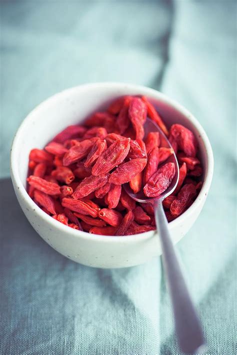 Dried Goji Berries In A Blue Bowl Photograph by Eising Studio | Fine Art America