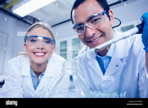 Science students using pipette to fill beaker Stock Photo - Alamy