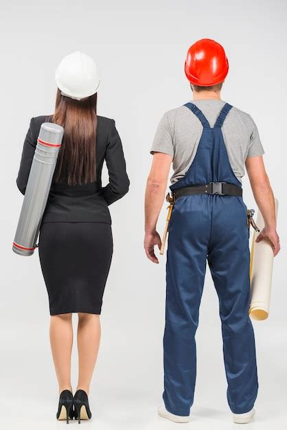 Woman engineer in suit standing with builder | Free Photo