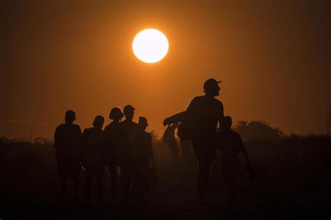 Silhouette of people walking on the beach at golden sunset 2029275 Stock Photo at Vecteezy