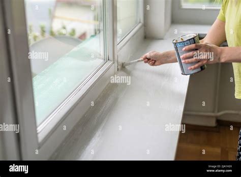 painting a window frame with white color Stock Photo - Alamy