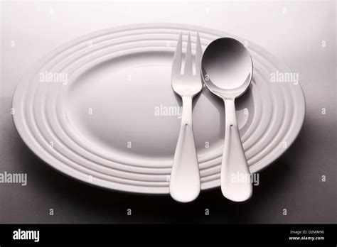 a plate with spoon and fork Stock Photo - Alamy