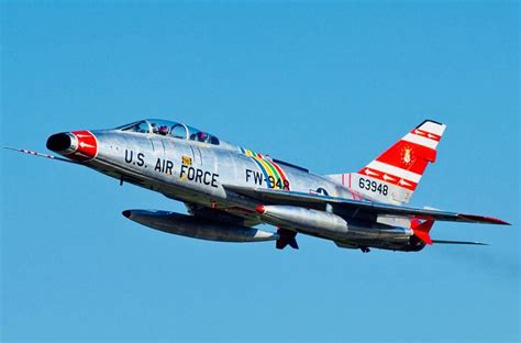 a silver fighter jet flying through a blue sky