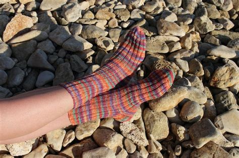 Premium Photo | A pair of socks on a beach with a rock background.