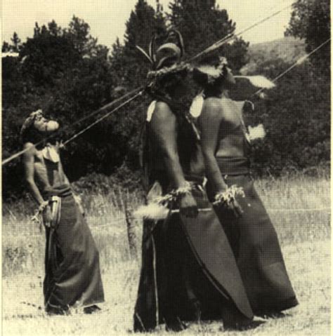 This image depicts the sun dance, a native american ritual where people dance around a pole with ...