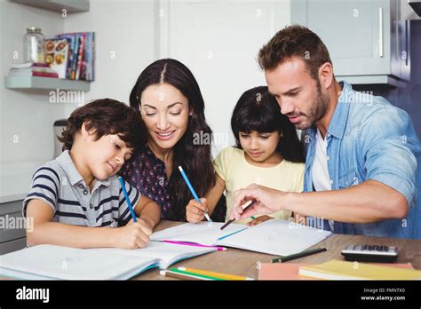 Parents assisting children doing homework Stock Photo - Alamy