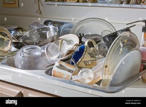 Dirty dishes piled up in the kitchen sink Stock Photo - Alamy