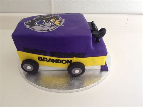 a purple and yellow birthday cake with wheels