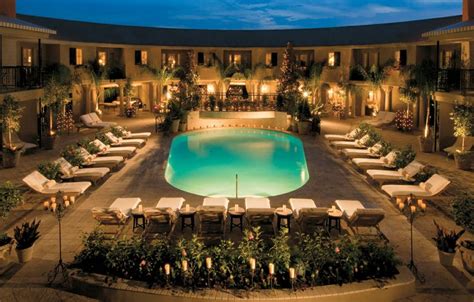 an indoor swimming pool surrounded by lounge chairs and potted plants ...