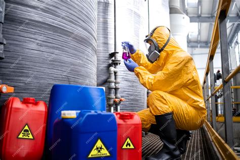 Trabajador de una fábrica de productos químicos con traje de protección y máscara de gas que ...