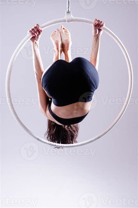 A female Aerial hoop gymnast performing exercises on an Aerial hoop ...