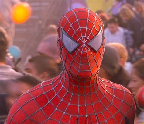 a man dressed as spider - man standing in front of a crowd