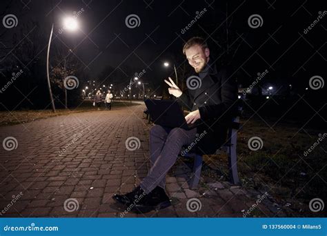 Dark Night, One Young Man, 20-29 Years, Sitting on Bench Alone, Using His Laptop in Public Park ...