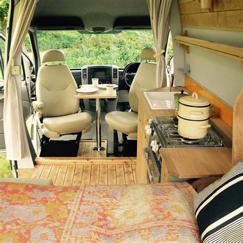 the interior of a camper van with two chairs and a table in front of it