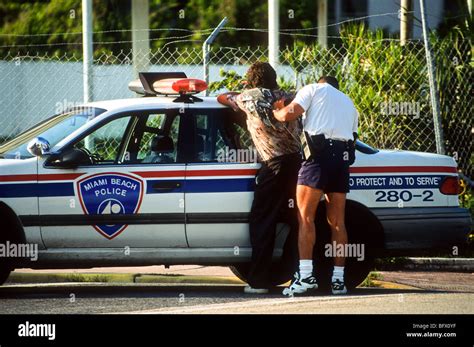 A Miami Beach police officer searches a suspect in Miami, Florida Stock ...