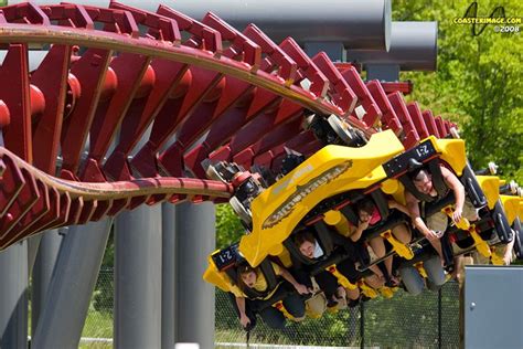 several people are riding roller coasters in an amusement park or theme park with red and yellow ...