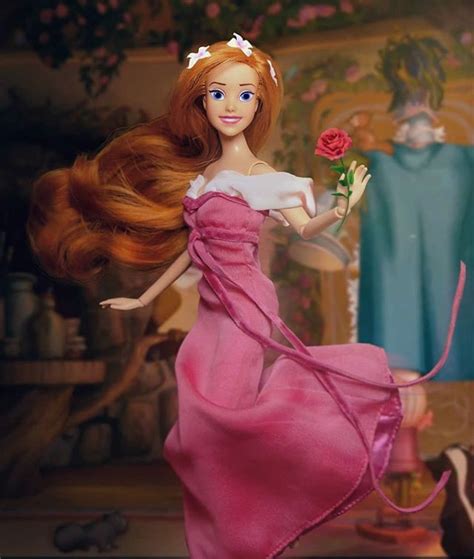 a doll with long red hair holding a rose in her hand and wearing a pink ...