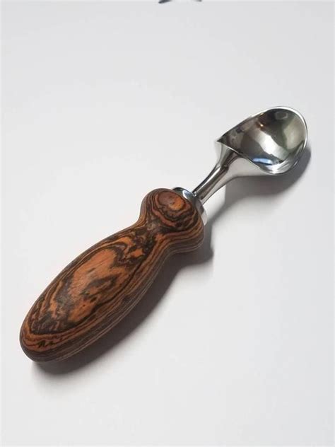 a spoon with a wooden handle on a white surface