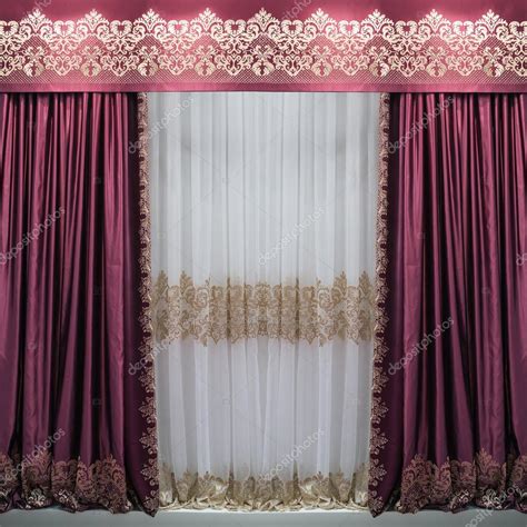 The satin purple curtains, pelmet with ornaments and a white translucent tulle with a pattern ...