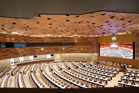 an empty auditorium with rows of seats and a large screen on the wall ...