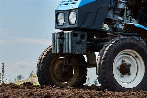 A tractor on the field plant potatoes and cultivates the ground ...