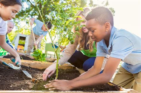 Teacher instrucing students while gardening during science class