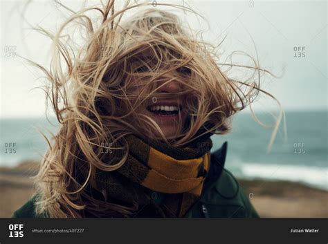 Blonde woman with wind-blown hair on a beach, Montauk, New York stock photo - OFFSET