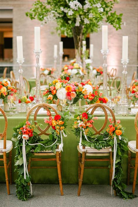 The couple chose their chairs because they resembled love knots. Flowers and greenery garlands ...