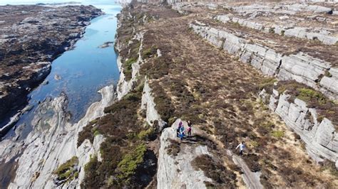 Premium Photo | A group of people hiking on a cliff above a river