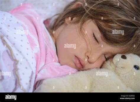 Child sleeping with teddy bear in bed Stock Photo - Alamy