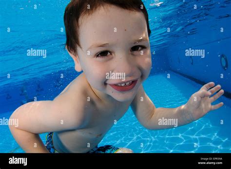 Young boy holds her breath while floating underwater Stock Photo - Alamy