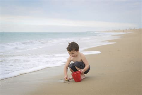 photo of boy digging up sand on the beach by Karyn Olsson - Click Magazine