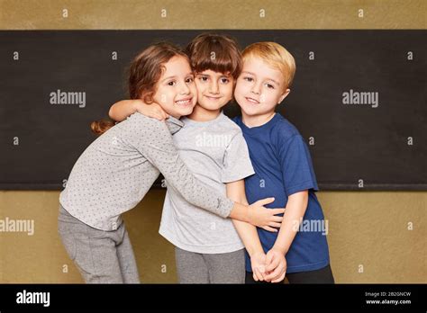 Group of kids as friends in kindergarten hugs each other Stock Photo ...