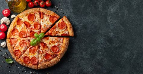 Tasty pepperoni pizza on a black concrete background. | Premium Photo