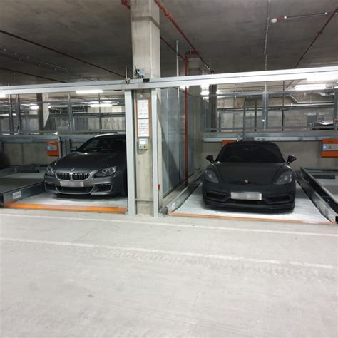 two cars parked in a parking garage with metal railings on the sides and doors open